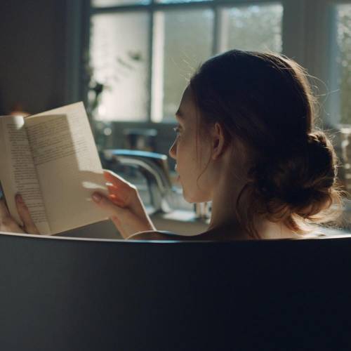 Woman reading a book and having a bath